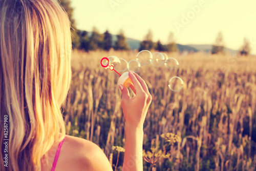 Fotografie Woman blowing soap babbles