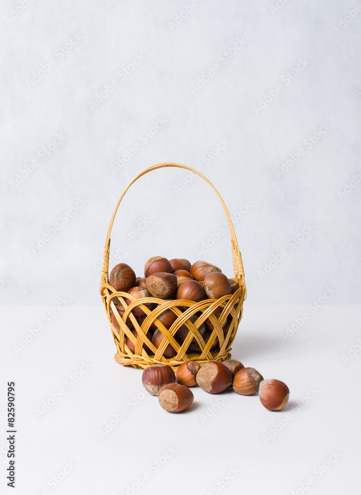 dried hazelnuts in basket on white background
