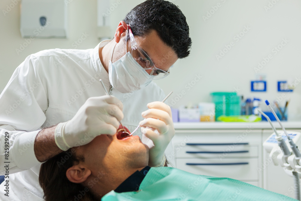 dentist is doing a checkup on a 40 years old man dentist is doing a checkup on a 40 years old man