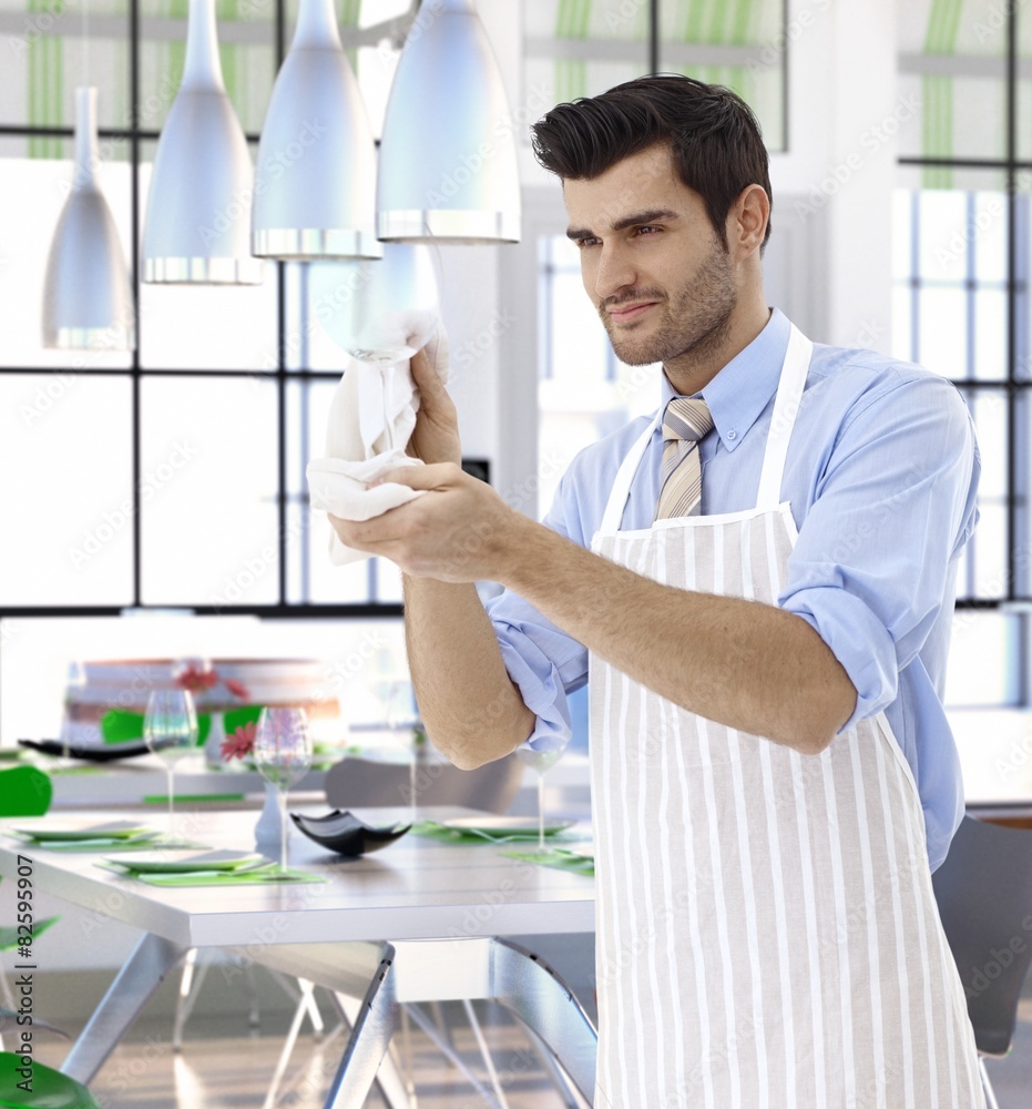 Waiter cleaning wineglass at restaurant Waiter cleaning wineglass at restaurant