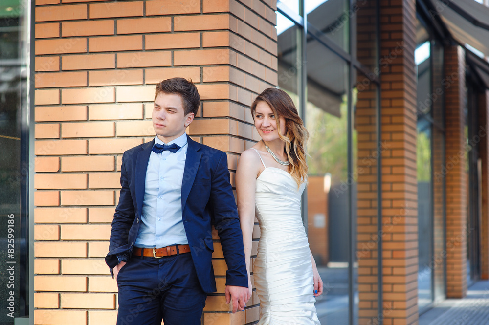 bride and groom are standing on the corner of the house and hold bride and groom are standing on the corner of the house and hold