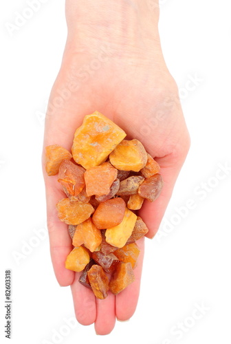 Hand of woman with raw ambers on white background