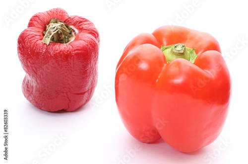 Fresh and wrinkled peppers on white background