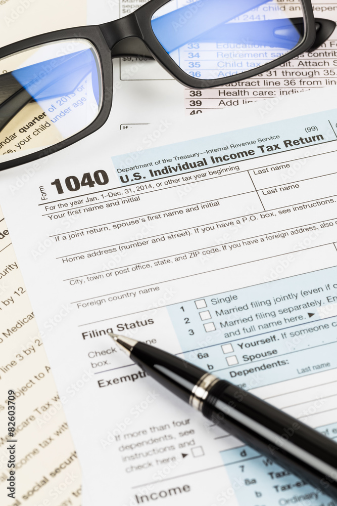 Tax form with glasses, and pen taxation concept Tax form with glasses, and pen taxation concept
