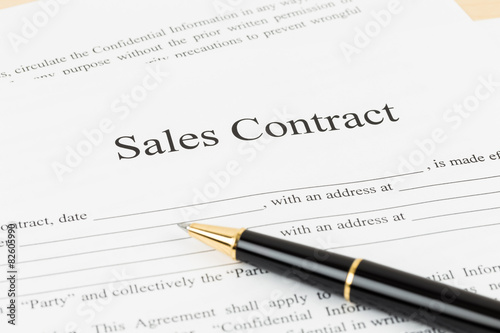 Sales contract document with pen, document is mock-up