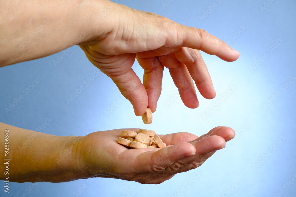 Closeup of senior woman's hand holding medications Closeup of senior woman's hand holding medications