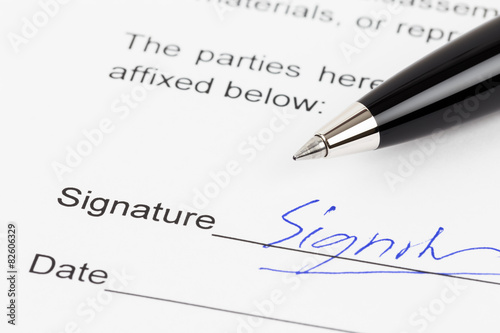 Signature on document with pen, signature is mock-up