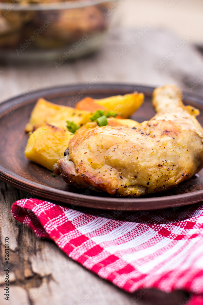 Baked chicken pieces with potatoes, herbs and garlic 