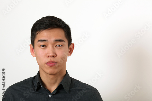 Serious young Asian man looking at camera