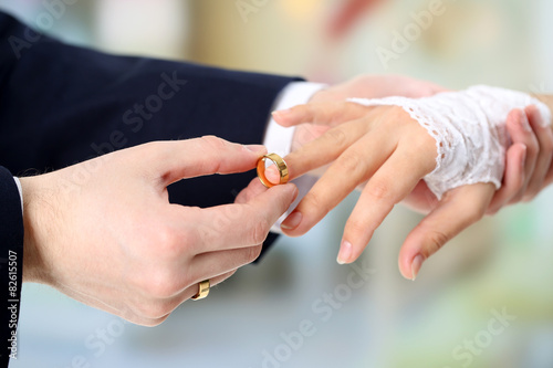 Woman and man holding wedding rings, close-up, on bright background
