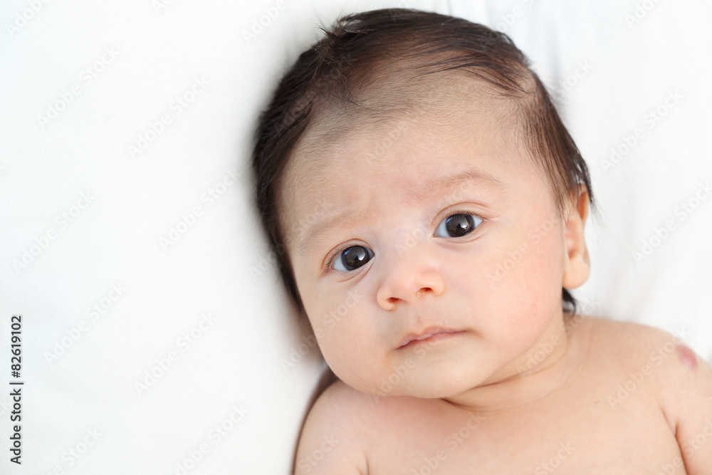 The cute baby boy is happy relax closeup on the white bed