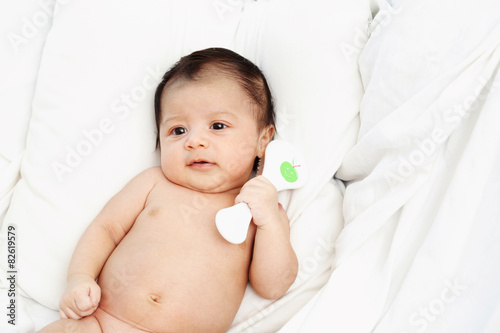 Cute baby is hug comb on white bed. Family concepts