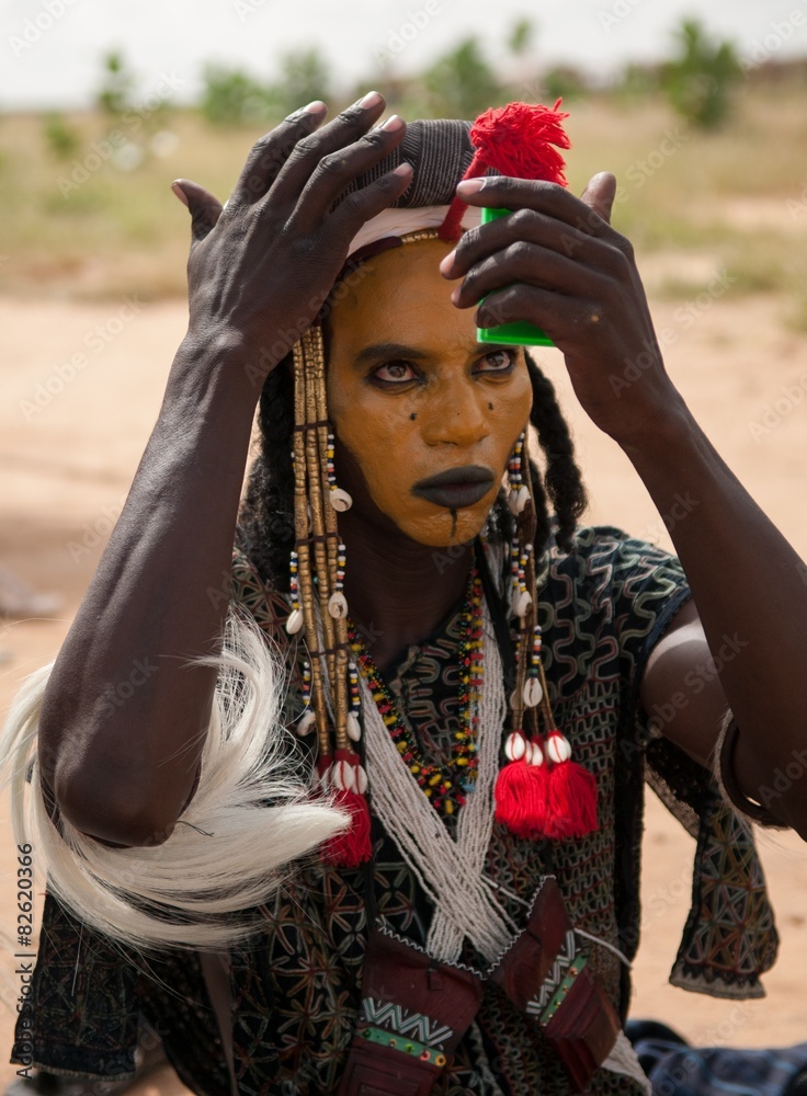 Wodaabe man checking makeup in a mirror, Gerewol, Niger Wodaabe man checking makeup in a mirror, Gerewol, Niger