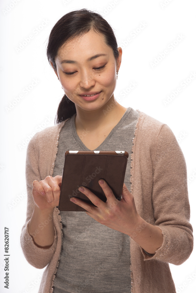 Young Asian woman in studio using tablet pc computer
