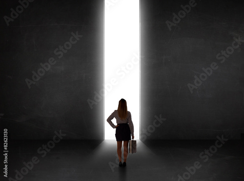 Business person looking at wall with light tunnel opening