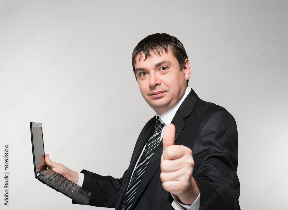 businessman holding a laptop, thumb to the top businessman holding a laptop, thumb to the top