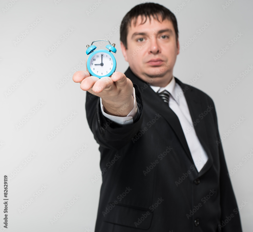 man holding an alarm clock in hands man holding an alarm clock in hands