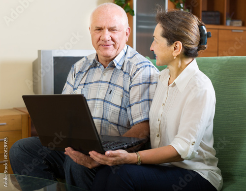 man and  woman using laptop at home