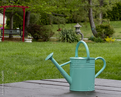 Tourquoise watering can next to gardens