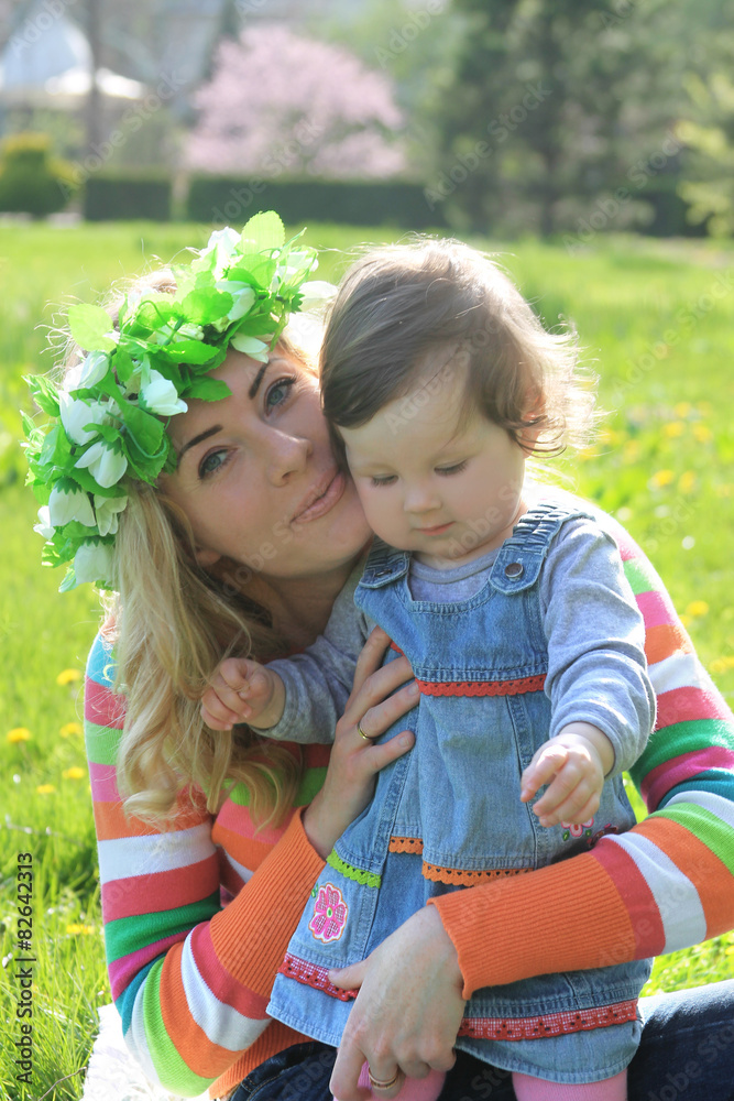 Mother hugging baby girl in spring lawn Mother hugging baby girl in spring lawn