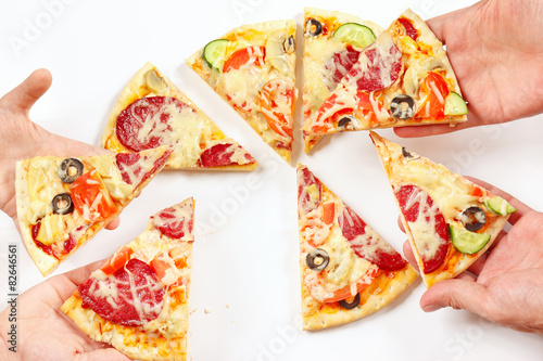 Child and adult hands snapping up pieces of a flavored pizza