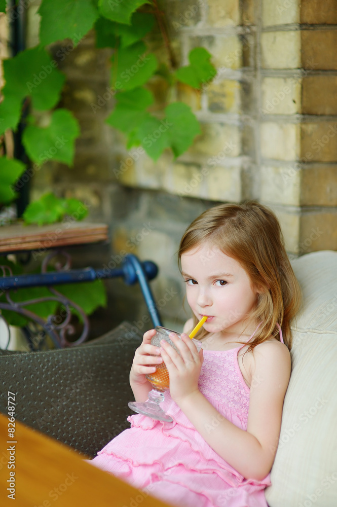 Adorable little girl drinking orange juice Adorable little girl drinking orange juice