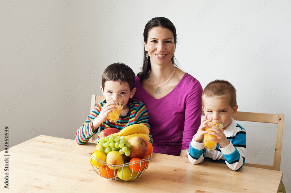 Fototapeta premium Happy healthy family drinking an orange jiuce
