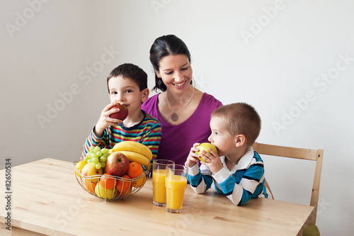 Children with their mother eating apples