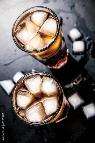 cola with ice on a wooden background. soft drinks