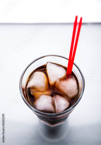 Cola in a glass with ice with red tube. soft drinks