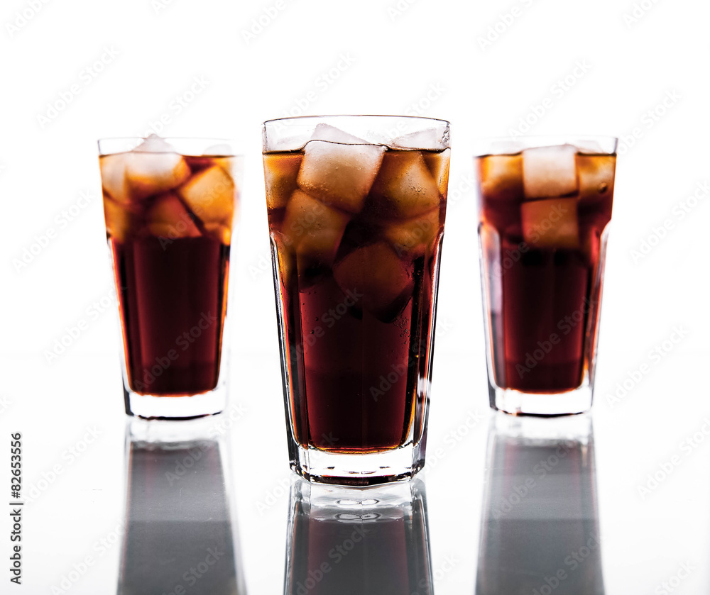 three glasses of cola and ice on a white background. soft drinks three glasses of cola and ice on a white background. soft drinks
