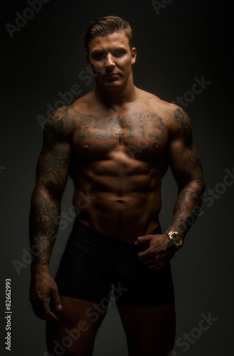 Muscular man with tattooes in deep shadows © Fxquadro