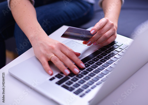 Woman sitting at the desk, shopping with laptop and credit card © lenetsnikolai