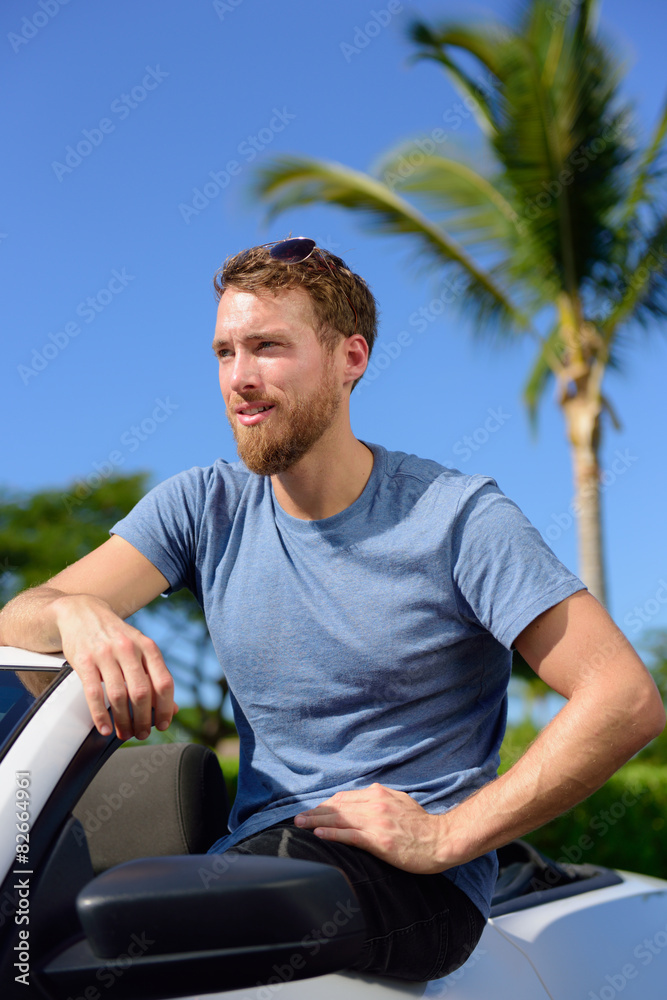 Handsome man showing off new luxury cabriolet car Handsome man showing off new luxury cabriolet car
