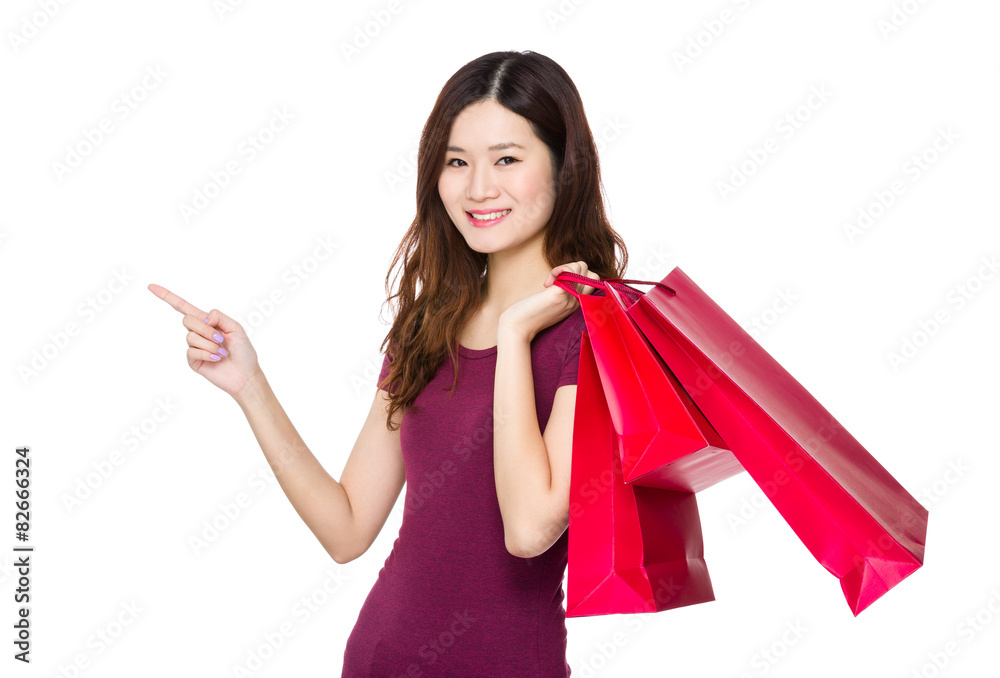 Young woman hold with shopping bag and finger point upwards Young woman hold with shopping bag and finger point upwards