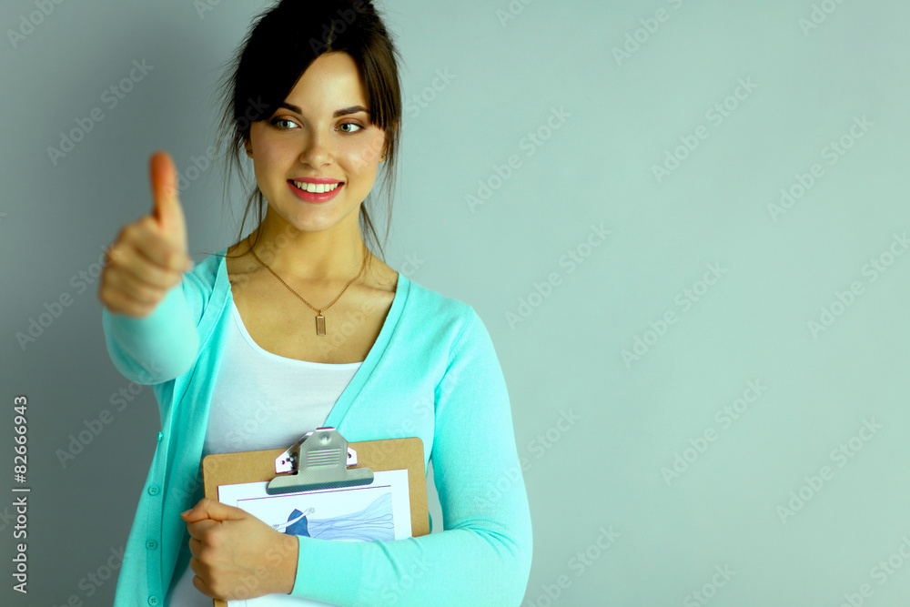 Young attractive fashion designer holding folders Young attractive fashion designer holding folders