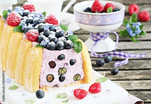 Homemade yogurt mousse cake ( charlotte ) with fresh berries.