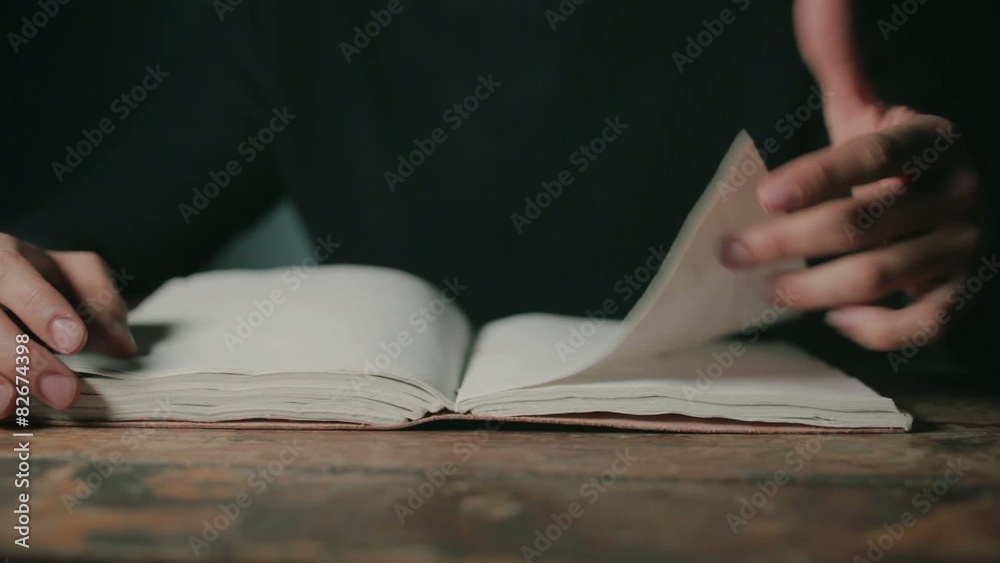 Man at desk flipping through notebook