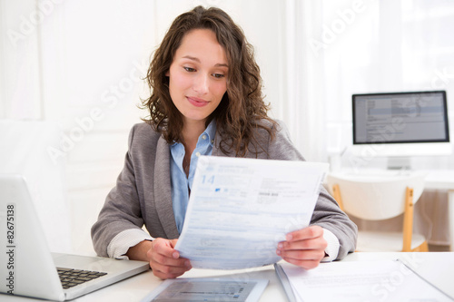 Obraz na płótnie Young attractive woman doing paperwork w salonie