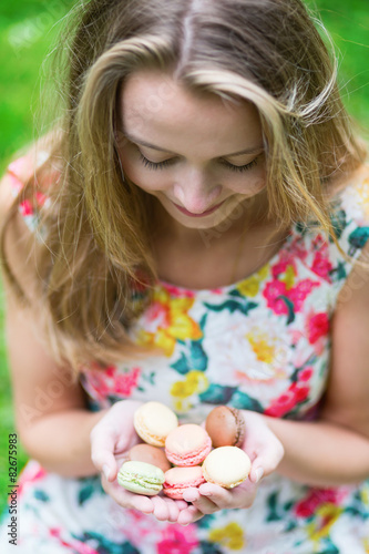 Girl holding French macaroons in hands