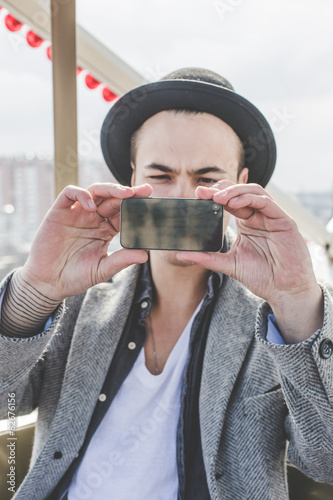 handsome young hipster guy taking selfie with his smart phone