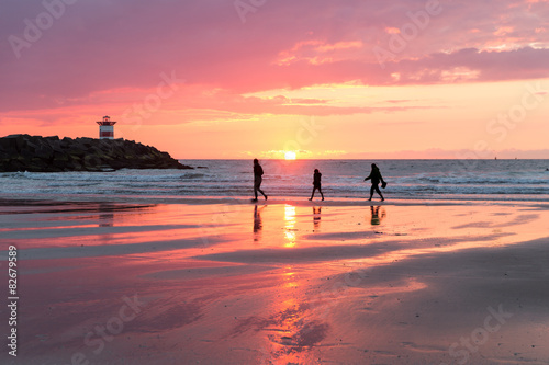Quadro em tela Sunset at the Dutch coast near Scheveningen with passing walkers