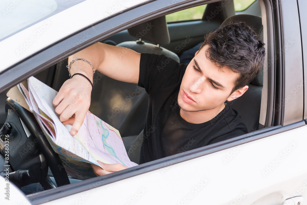Young Man showing map inside of a car
