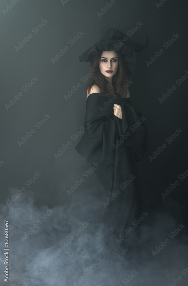 slender witch in a smoke on  black background