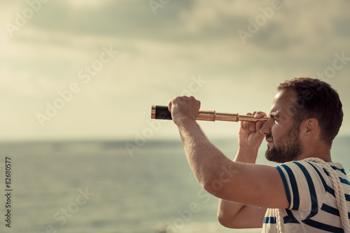 Sailor man looking through the binoculars