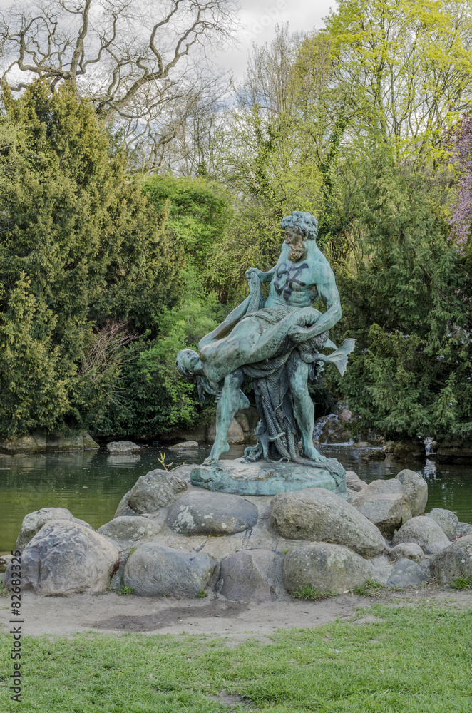 A bronze statue of a fisherman holding a mermaid