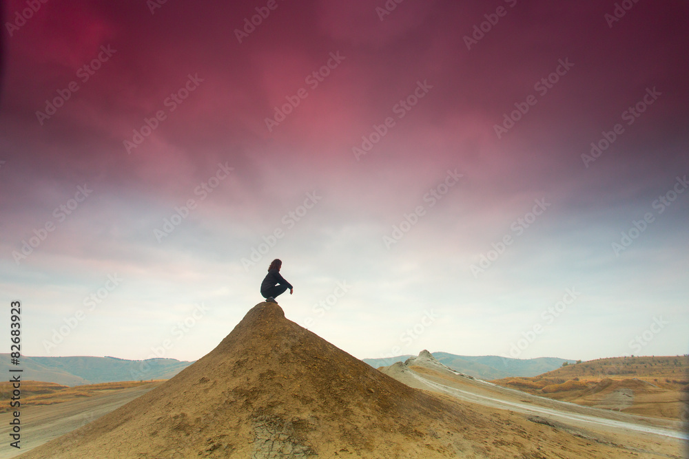 Silhouette of woman meditating on top of a hill