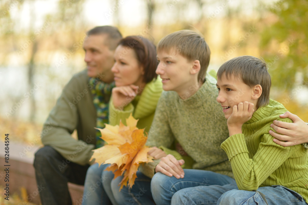 Family relaxing in autumn park