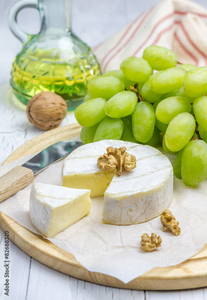 Soft brie cheese with sweet grapes and nuts closeup Soft brie cheese with sweet grapes and nuts closeup