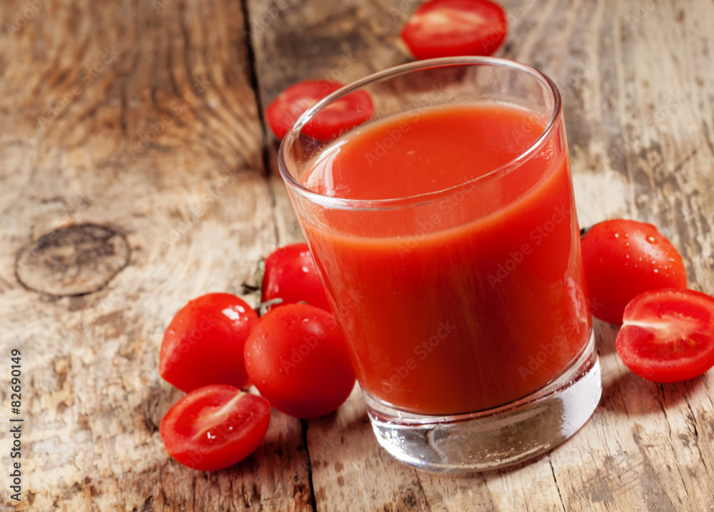 Fresh tomato juice and tomatoes on the table, selective focus Fresh tomato juice and tomatoes on the table, selective focus